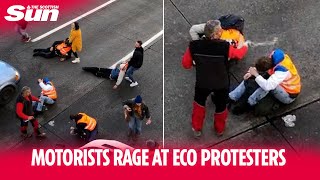 Motorists rage at eco protesters by throwing water on them and hauling them across motorway [upl. by Alyakcim95]