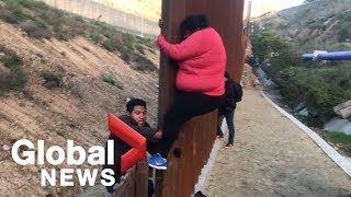 Migrant families continue to spill over Tijuana border fence head to US [upl. by Pros81]