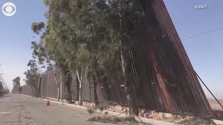 Wind blows newly installed section of the border wall over into Mexico [upl. by Onitsuaf]