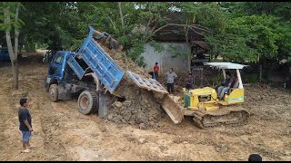 Pushing project hard working bulldozer pushing land trucks in muddy after raining [upl. by Kristoforo]