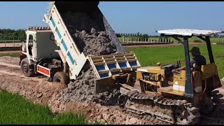 Urban development Processing Filling Up The Land Bulldozer KOMATSU D31P Dump Truck unloading [upl. by Tamma]